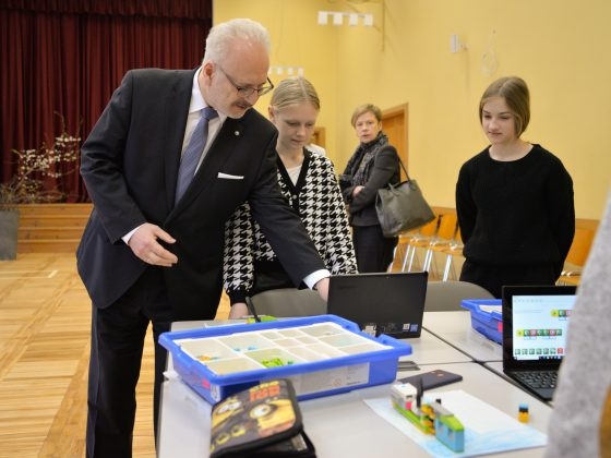 E. Levits apskata skolēnu paveikto robotikas nodarbībā pie galda