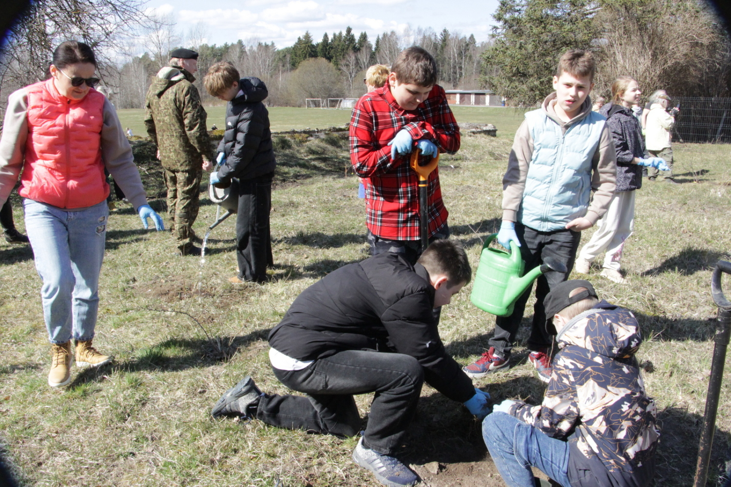 Foto ar skolēniem, kas stāda kokus