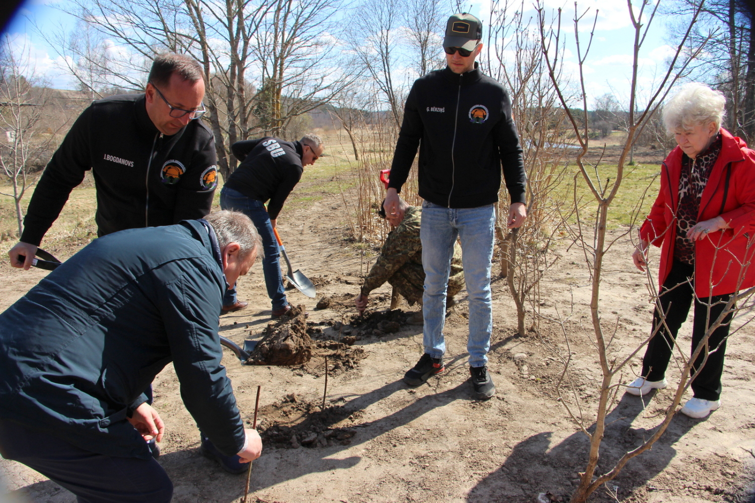 Foto ar Brīvprātīgo ugunsdzēsēju biedrības darbiniekiem, kas stāda kokus