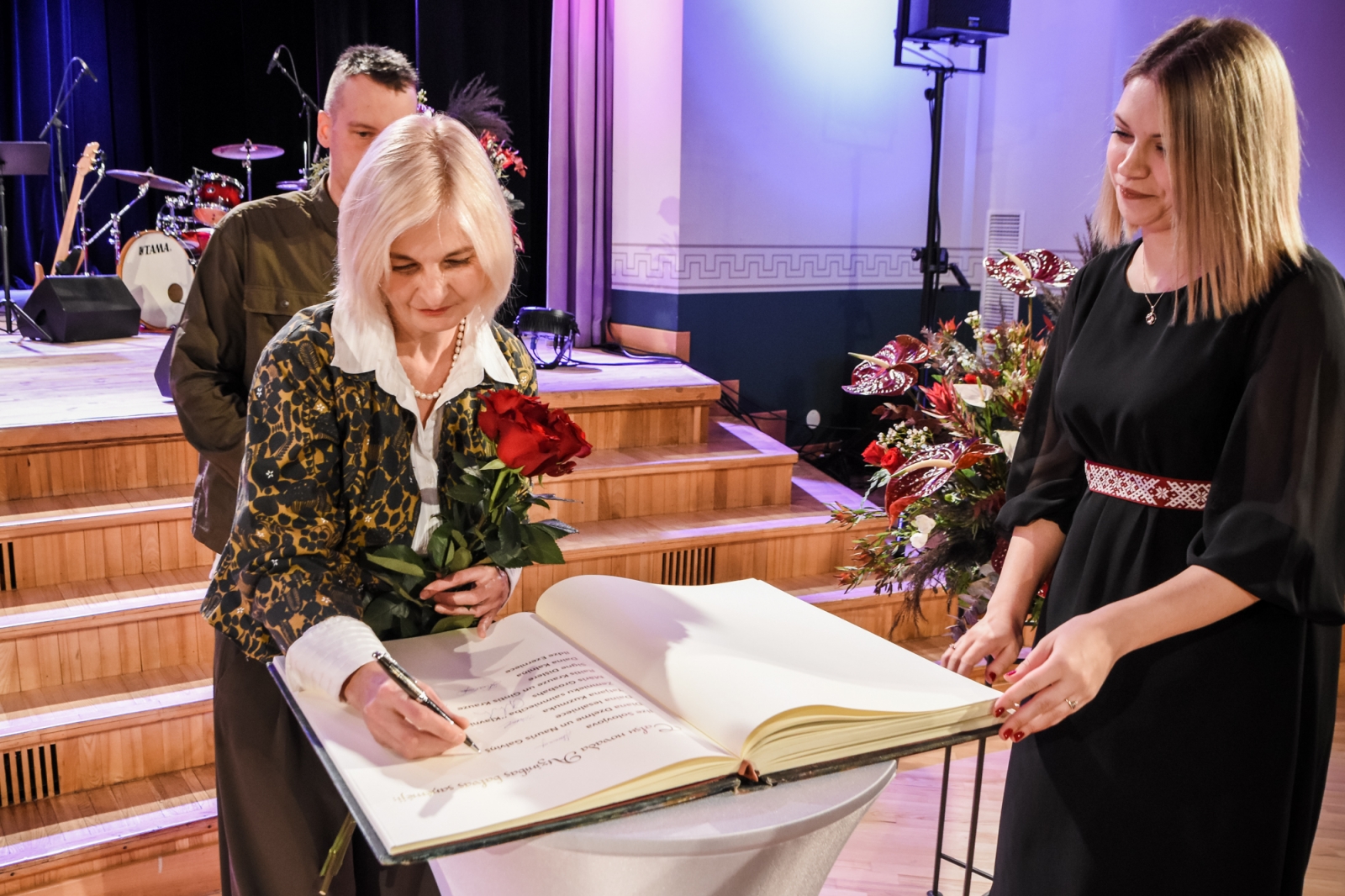 Diana Dzelme parakstās Talsu novada Goda grāmatā, blakus Dana Vecmane, aizmugurē Nauris Galviņš (44)